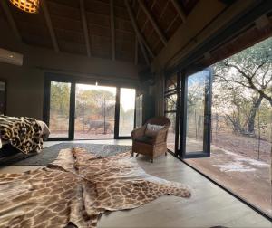 LephalaleSimba Safaris African Pride Exotic Lodge的卧室的地板上铺有长颈鹿地毯。