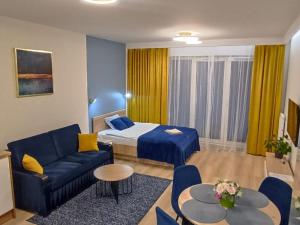 比亚韦斯托克Apartament Centrum Białystok的酒店客房,配有床和蓝色的沙发