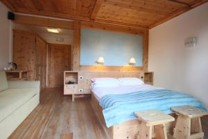 科尔蒂纳丹佩佐Ciasa Vervei的一间卧室设有一张大床和两张木制长椅。