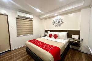 马尼拉Khotel Pasay的一间卧室配有一张带红色毯子的大床