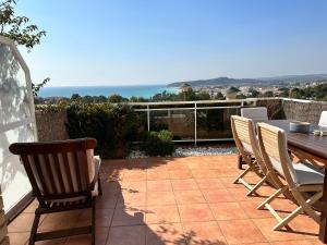 阿尔塔夫拉Villa Alex Altafulla Hermosa casa con espectaculares vistas al mar y a tocar de una idílica calita的一个带桌椅的庭院和大海