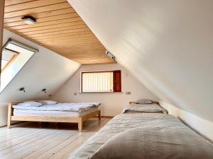 KrüüdneriKrüüdneri puhkemaja的阁楼卧室设有2张床和木制天花板