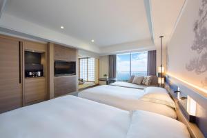 小田原市小田原希尔顿Spa度假酒店的酒店客房设有三张床和电视。