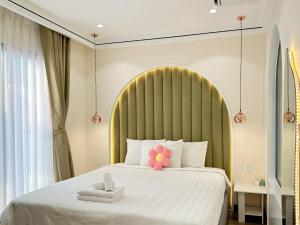 胡志明市The Royal Homies - Phu My Hung的一间卧室配有一张大床,床上放着鲜花