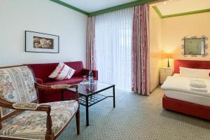 巴德贝芬森Golf- und Wellnesshotel Amtsheide的客厅配有沙发和1张床
