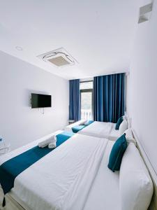 富国Beach Hotel Grand World (La La Homestay)的一间卧室配有两张带蓝色枕头的床