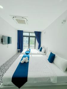 富国Beach Hotel Grand World (La La Homestay)的一间卧室配有两张大床和蓝色枕头
