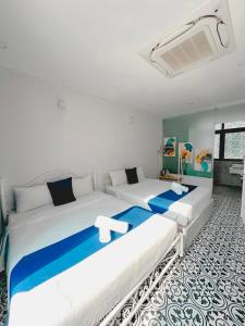 富国Beach Hotel Grand World (La La Homestay)的蓝色和白色的客房内的两张床