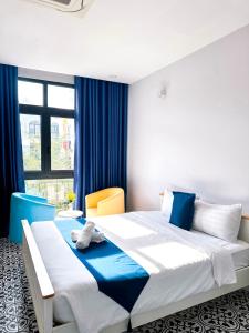富国Beach Hotel Grand World (La La Homestay)的一间卧室配有一张带蓝色窗帘的大床