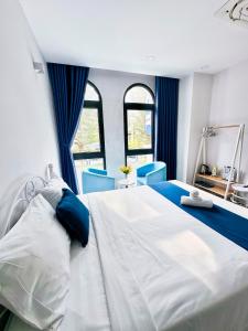 富国Beach Hotel Grand World (La La Homestay)的卧室配有白色大床和蓝色椅子