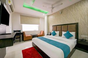 新德里Hotel Atlantis suites Near Delhi Airport的一间卧室配有一张大床、一张桌子和一张书桌