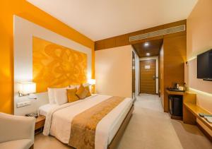 新德里Hotel Atlantis suites Near Delhi Airport的酒店客房设有一张大床和一台电视。