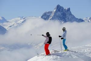 瓦尔德阿尔贝格Hotel Sonnblick的两个人站在雪覆盖的山顶上