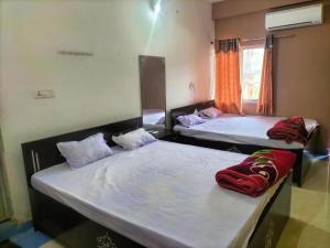 PatrātuHotel Shobha and Tent House的两张床位于带窗户的房间内