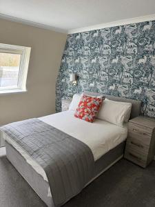 德拉姆纳德罗希特Loch Ness Drumnadrochit Hotel的一间卧室配有一张带花卉壁纸的大床