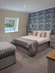 德拉姆纳德罗希特Loch Ness Drumnadrochit Hotel的一间卧室设有一张大床和一个窗户。