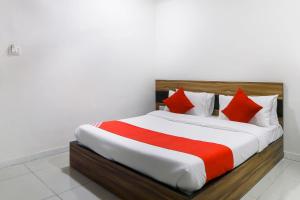 巴罗达OYO Hotel Shiv Kunj的一间卧室配有一张带红色枕头的大床