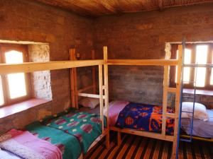 廷吉尔Auberge Hostel Traditionnel的小屋内设有一间带两张双层床的卧室