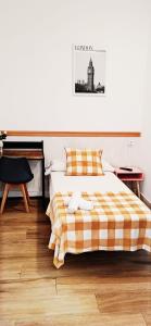 韦尔瓦HOSTEL COSTA-LUZ Béjar的一间卧室配有一张带 ⁇ 子毯子的床