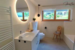 贝里斯泽尔Homely Stay Velosoph Quartier的一间带水槽、卫生间和镜子的浴室