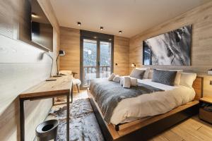 索尔德乌Luxury Ski Chalet Andorra的一间卧室配有一张大床和一张书桌