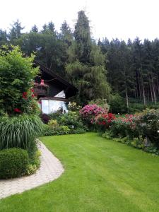 奥西阿赫Blumenpension Strauss - Ferienwohnungen的一座鲜花盛开的花园,一座建筑