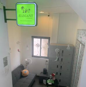 胡志明市Elegant Homestay Sai Gon的客厅配有沙发和墙上的标志