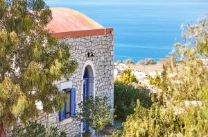 卡米拉日Orelia Cretan Deluxe Apartments的一座教堂,设有红色屋顶,享有海景