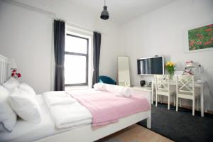 卢布尔雅那BIT apartments的白色卧室配有白色的床和书桌