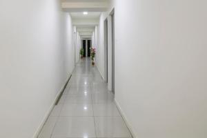 巴罗达OYO Hotel Shiv Kunj的白色墙壁的建筑里空的走廊