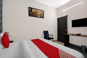 法里达巴德Flagship Hotel Sangeet的一间卧室配有一张床、一张书桌和一台电视。