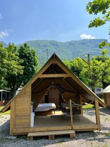 莱科Glamping Camping Rivabella的木制帐篷配有桌椅