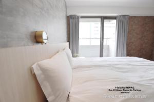 台中市塔木德酒店Choice 台中一中馆的卧室配有白色的床和窗户