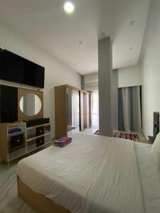 沙姆沙伊赫Jasmine Resort & Aqua park的卧室配有一张白色大床和电视。