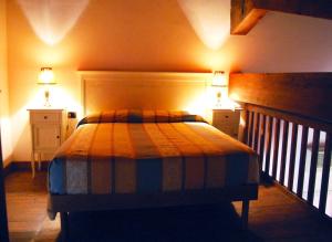 伊索拉迪卡波里祖托Borghetto Beach Club Resort的一间卧室配有一张带2个床头柜和2盏灯的床。