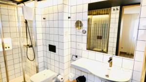 比利亚霍约萨Pou by Seaward Suites Only Adults的一间带卫生间、水槽和镜子的浴室