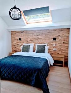 胡法利兹Hotel L'ermitage的一间卧室设有一张带砖墙的大床