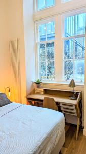 爱丁堡Luxury One Bedroom Apartment in the City Centre的一间卧室配有一张桌子、一张床和一个窗户