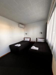 SansonBrooklyne Motel Sanson的客房设有两张床和窗户。