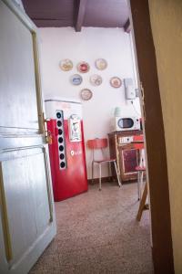 维托尔基亚诺Casetta dei Nonni的一间房间,墙上装有红色冰箱和盘子