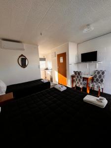 SansonBrooklyne Motel Sanson的酒店客房带一张床、一张桌子和椅子
