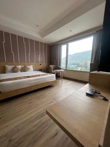 古瓦哈提Sachika Hotels, Guwahati的一间卧室设有一张大床和一个大窗户