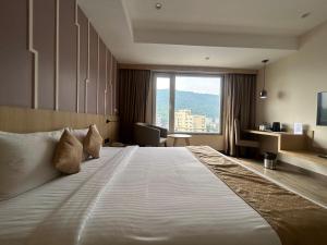 古瓦哈提Sachika Hotels, Guwahati的一张位于酒店客房的大床,设有窗户