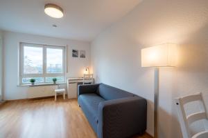 菲尔斯滕瓦尔德2 Zimmer mit Balkon, Wohnzimmer mit Arbeitsplatz, zentral, top!的客厅设有蓝色的沙发和窗户。