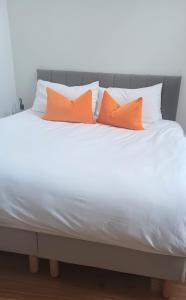 爱丁堡Luxury One Bedroom Apartment in the City Centre的白色床上的2个橙色枕头