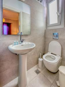 米克诺斯城曼托酒店的一间带卫生间、水槽和镜子的浴室