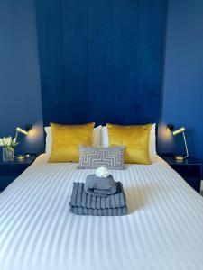 诺里奇Luxury Norwich City Centre Apartment - Free Parking的一张白色大床,配有黄色枕头和蓝色的墙壁