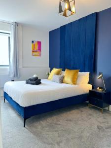 诺里奇Luxury Norwich City Centre Apartment - Free Parking的一间卧室配有一张带蓝色墙壁的大床
