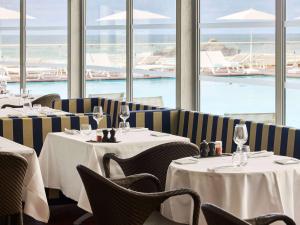 比亚里茨索菲特币艾日兹米拉玛尔塔拉斯酒店的一间设有桌椅的海景餐厅
