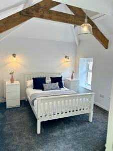LaxeyThe Cottage, Bridge House的一间卧室配有白色床和蓝色枕头
